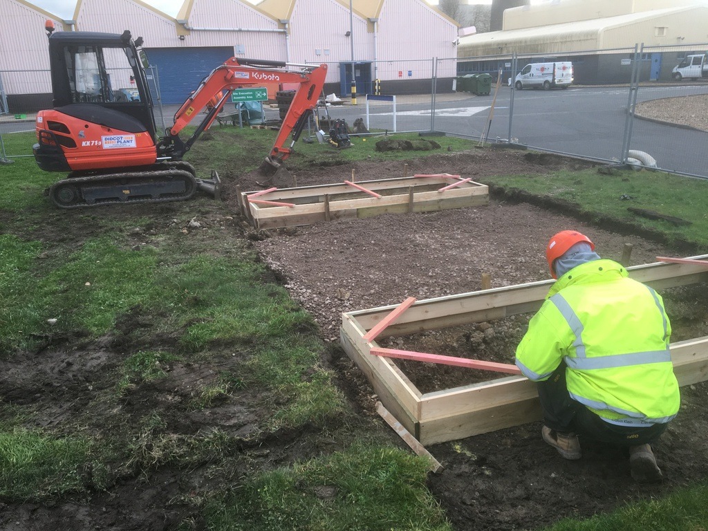 Excavator and construction worker outdoors