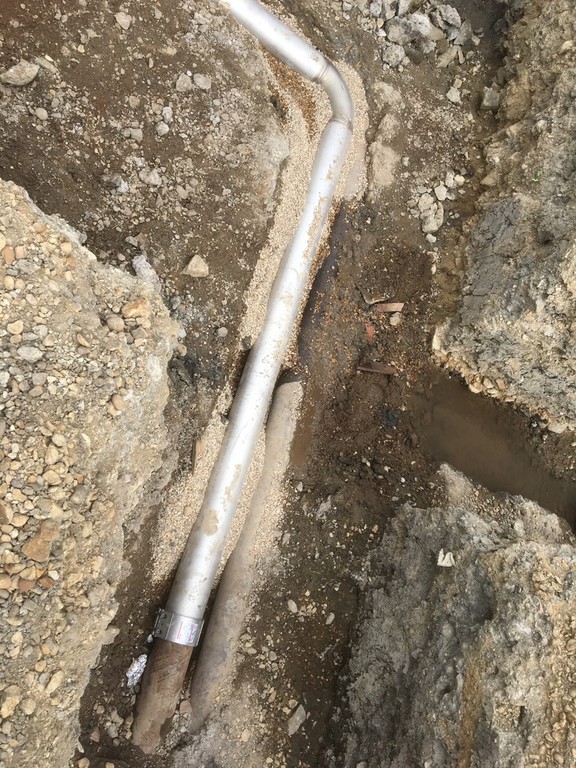 Exposed pipeline in muddy trench