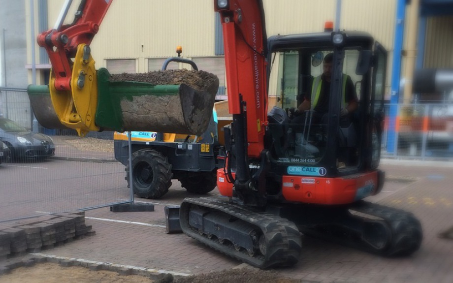 Excavator lifting a large log